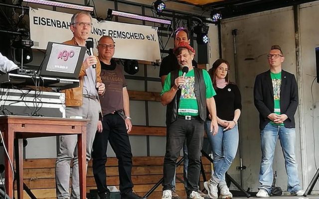 Bezirksbürgermeister Andreas Stuhlmüller, EWR-Wallbox-Pionier Stefan Zwanzig-Müller, Volker Beckmann (†), Oliver Grünberg, Anne Marie Faßbender und Sascha von Gerishem (v.l.) stehen auf der Heimatbunt-Bühne. Foto: Elke Gorka
